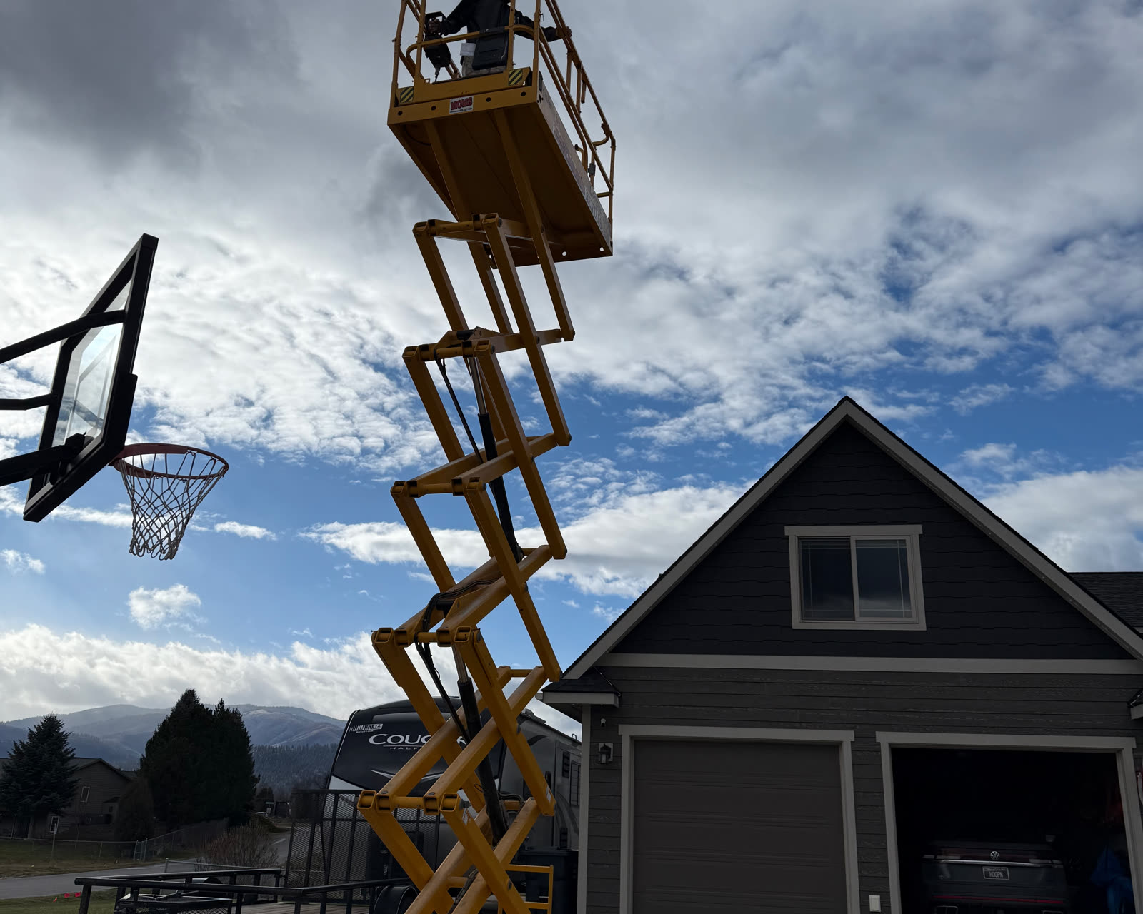 Our crew installing roofline lights from a lift by Montana Lights
